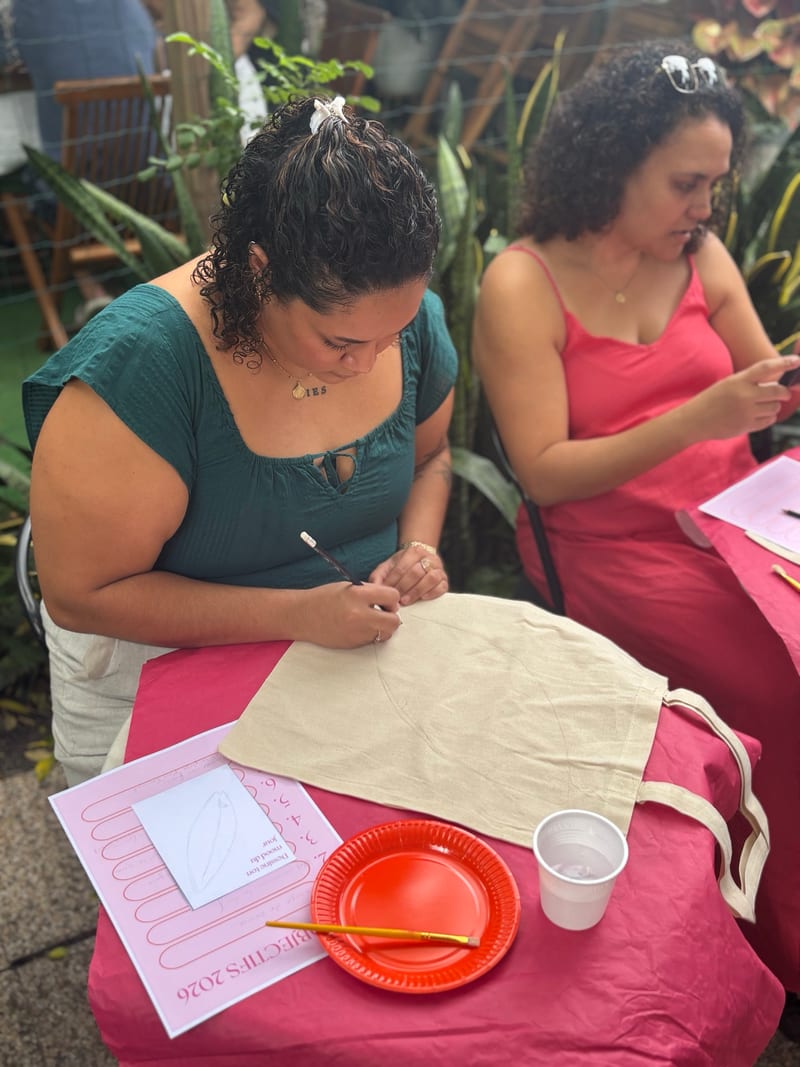 Deux participantes concentrées sur la personnalisation de leur tote bag
